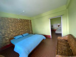 um quarto com uma cama, um espelho e um sofá em DPM HOMESTAY em Bomdila