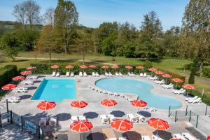 克雷西拉沙佩勒Camping Country Park Crecy La Chapelle - Site Officiel - Next to Disneyland Paris的一个带红色和白色遮阳伞及椅子的游泳池