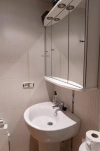 a white bathroom with a sink and a mirror at Acogedor Apartamento en Oviedo Frente al HUCA in Oviedo