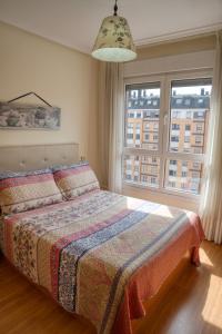 - une chambre avec un lit et une grande fenêtre dans l'établissement Acogedor Apartamento en Oviedo Frente al HUCA, à Oviedo