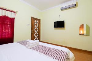 sypialnia z łóżkiem i telewizorem na ścianie w obiekcie Homestay Nike Bed w mieście Kembanglimus