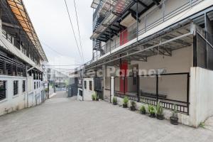 einen leeren Innenhof eines Gebäudes mit Topfpflanzen in der Unterkunft Maleo Residence Bandung Mitra RedDoorz in Bandung