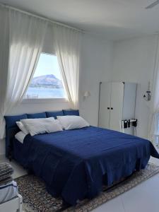 a bedroom with a blue bed with a window at Blue Life, sea-luxury rooms on the beach between Palermo and Cefalu' in Casteldaccia +106 photos
