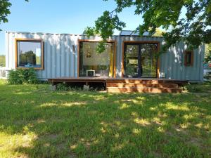 a tiny house in a yard with a bench at Miejsce dla chcących odpocząć in Prabuty