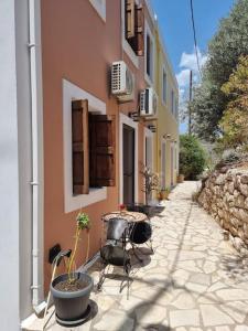 une passerelle en pierre avec des chaises et un bâtiment dans l'établissement Kavos House, à Megísti