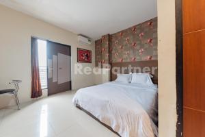 Ein Bett oder Betten in einem Zimmer der Unterkunft Maleo Residence Bandung Mitra RedDoorz