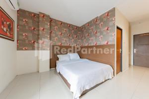 Ein Bett oder Betten in einem Zimmer der Unterkunft Maleo Residence Bandung Mitra RedDoorz