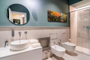 bagno con lavandino, servizi igienici e specchio di Aosta Holiday Apartments - Sant'Anselmo ad Aosta