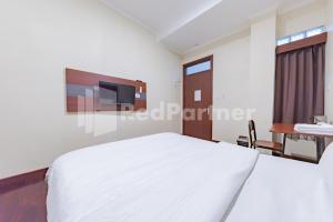 Ein Bett oder Betten in einem Zimmer der Unterkunft Maleo Residence Bandung Mitra RedDoorz