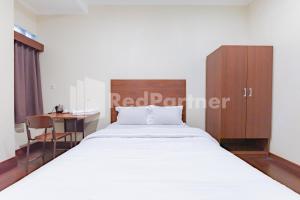 Ein Bett oder Betten in einem Zimmer der Unterkunft Maleo Residence Bandung Mitra RedDoorz