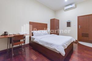 Ein Bett oder Betten in einem Zimmer der Unterkunft Maleo Residence Bandung Mitra RedDoorz