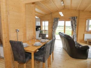 a wooden dining room with a table and chairs at Ty Presto, Parc Y Fronwen in Newborough