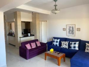 a living room with two purple couches and a table at Chalet Marina Alamein first row sea view 3 bedroom-North Coast in El Alamein