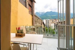 una mesa y sillas en un balcón con vistas en Aosta Holiday Apartments - Sant'Anselmo en Aosta