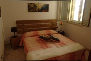 Schlafzimmer mit einem Bett mit einem Kopfteil aus Holz in der Unterkunft Casa Arcobaleno in Marsala