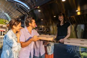 dos mujeres y un hombre sosteniendo una caja de pizza en Camping Country Park Crecy La Chapelle - Site Officiel - Next to Disneyland Paris, en Crécy-la-Chapelle