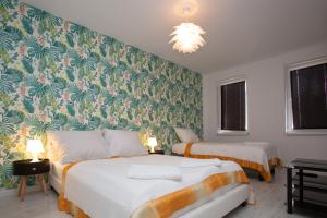 two beds in a room with green and orange wallpaper at OW STILO in Międzyzdroje
