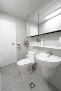 a white bathroom with a toilet and a sink at Greenery SEOUL in Seoul