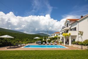 a villa with a swimming pool and a house at 3 Luxury bedroom Apartment EMMA in Sinj