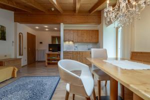 a kitchen and dining room with a table and chairs at Haus Zenoburg in Tirolo
