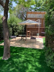 une terrasse avec une table, des chaises et un parasol dans l'établissement Rosh Pinat Noy, à Rosh Pinna