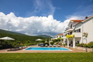 a villa with a swimming pool and a house at Apartman Nada in Sinj