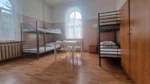 a room with a table and two bunk beds at SM PTSM Matecznik in Przemyśl
