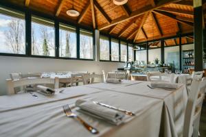 un comedor con mesas y sillas blancas y ventanas en Centro Turistico Città di Bologna en Bolonia