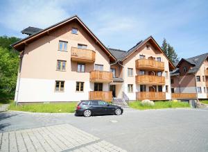 a black car parked in front of a building at Apartamenty EverySky - Nad Łomnicą 14A-B in Karpacz
