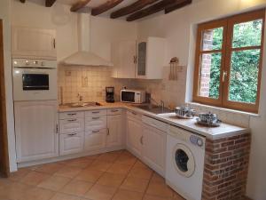 a kitchen with white cabinets and a washer and dryer at Maison Campagne Dix Kilomtres De in Hautot-lʼAuvray +14 photos