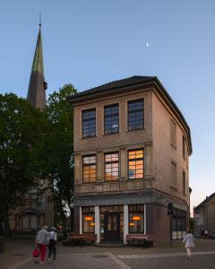 un edificio de ladrillo alto con gente caminando delante de él en Ferienwohnung mit malerischem Ausblick, en Billerbeck