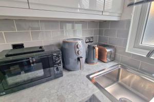 a kitchen counter with a microwave and a sink at Private Garden Studio near London free Freeparking in West Thurrock
