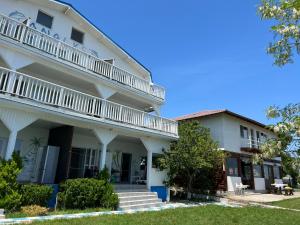 a large white building with white balconies on it at Casa Analys in Douăzeci şi Trei August