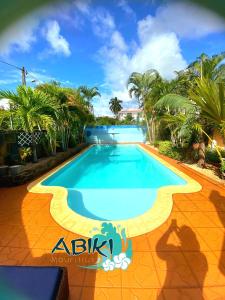 a swimming pool in a resort with palm trees at Maya-Abiki Mauritius in Albion