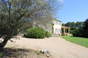 a house with a tree and a gravel driveway at Provence.bienvenue chez nous in Rognes
