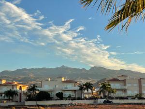 uitzicht op huizen, palmbomen en bergen bij Amarilla Golf Suite in San Miguel de Abona