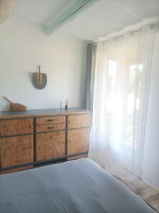 1 dormitorio con 1 cama con tocador y ventana en 7-gîte-7 personnes au cœur de la nature /piscine, en Saint-Aubin-de-Nabirat