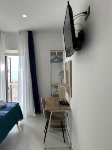 a bedroom with a desk and a television on a wall at VistAmare - Fuscaldo in Marina di Fuscaldo
