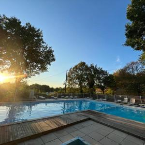 a swimming pool with the sun setting in the background at 7-gîte-7 personnes au cœur de la nature /piscine in Saint-Aubin-de-Nabirat