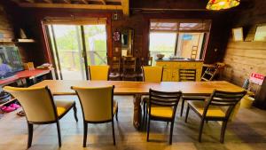 una sala da pranzo con un grande tavolo in legno e sedie di ログあした 船でしか行けない離島のヴィラ a Hinase