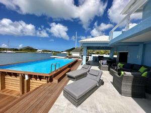 a patio with a swimming pool and a house at Blue Haven in Jolly Harbour