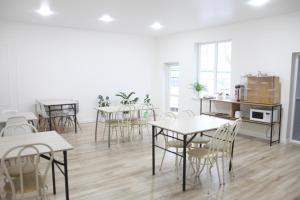 a room with tables and chairs and a kitchen at Jardin in Aktobe