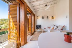 a living room with a couch and a tv at Baja di Li Ranci by DomusAway in Baja Sardinia