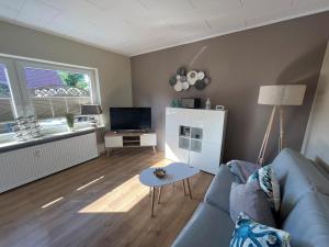 a living room with a couch and a tv at Hooge Hörn Bantje Wohnung 3 in Borkum