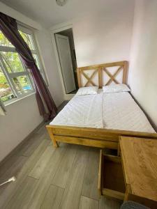 1 dormitorio con 1 cama grande con marco de madera en Qiwi House en Ureki