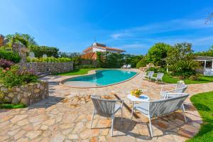 a patio with a table and chairs next to a pool at AMORE RENTALS - Resort Ravenna - Villa Dama in Massa Lubrense