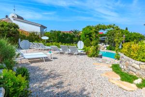 a backyard with chairs and a swimming pool at AMORE RENTALS - Resort Ravenna - Villa Dama in Massa Lubrense