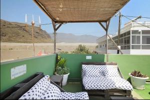 une terrasse avec une table, des chaises et un mur vert dans l'établissement Hacienda La Extremeña, à Güimar