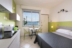 a bedroom with a bed and a kitchen with a table at Residence Casa e Vela in Oggebbio
