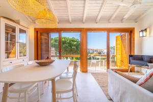 a kitchen and living room with a table and chairs at Baja di Li Ranci by DomusAway in Baja Sardinia
